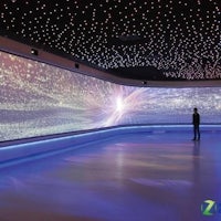 a man is standing in front of a large projection screen